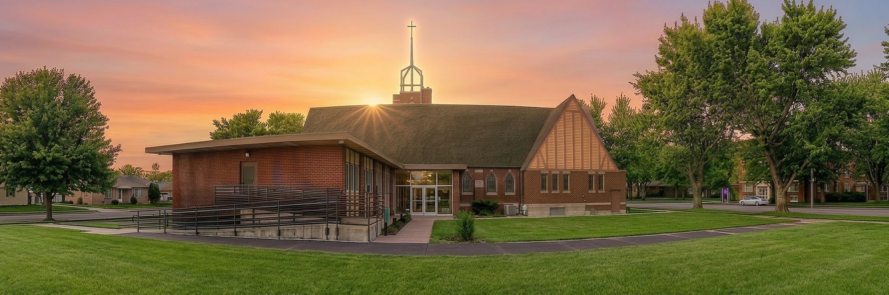 Historic Elim Lutheran Church exterior at sunset, with its steeple and accessible entrance ramp